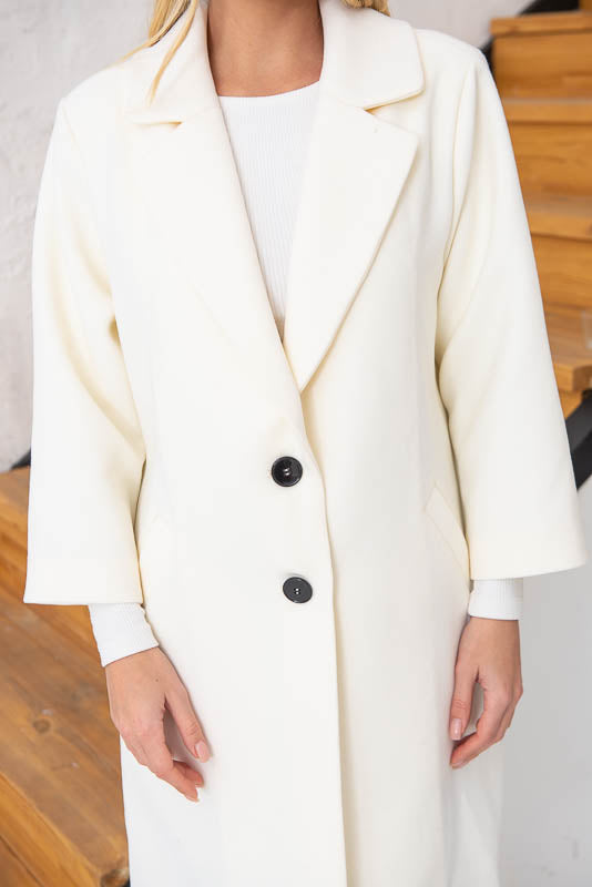 Unlined coat. Buttoned. Three-quarter sleeves. Wool and cashmere blend.