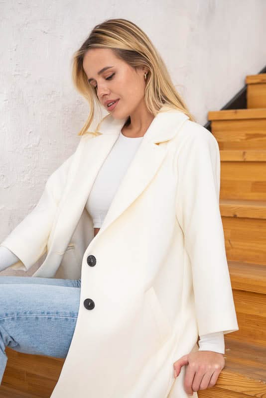 Unlined coat. Buttoned. Three-quarter sleeves. Wool and cashmere blend.