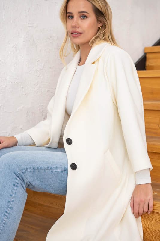 Unlined coat. Buttoned. Three-quarter sleeves. Wool and cashmere blend.