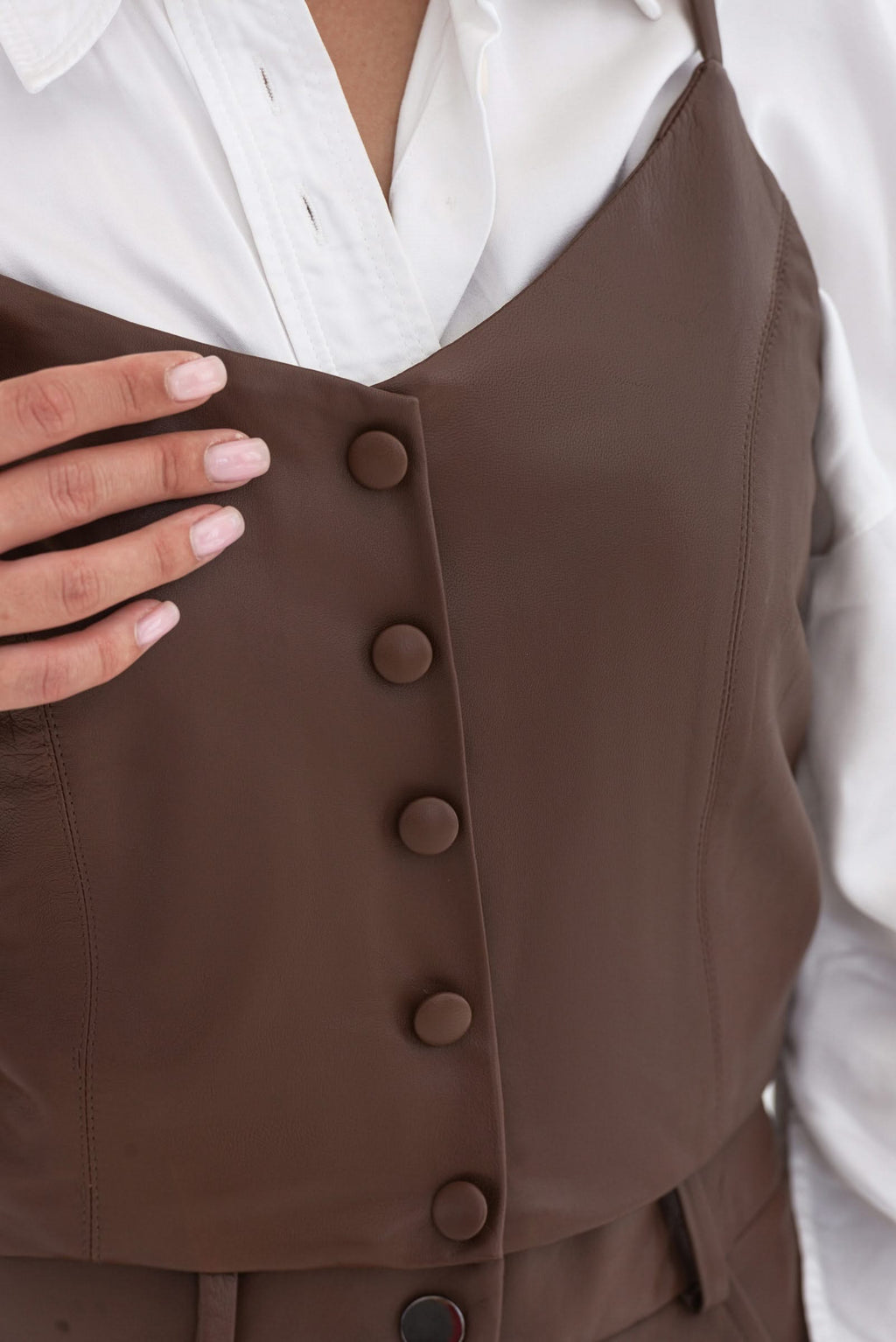 Spaghetti strap top with decorative buttons. Leather