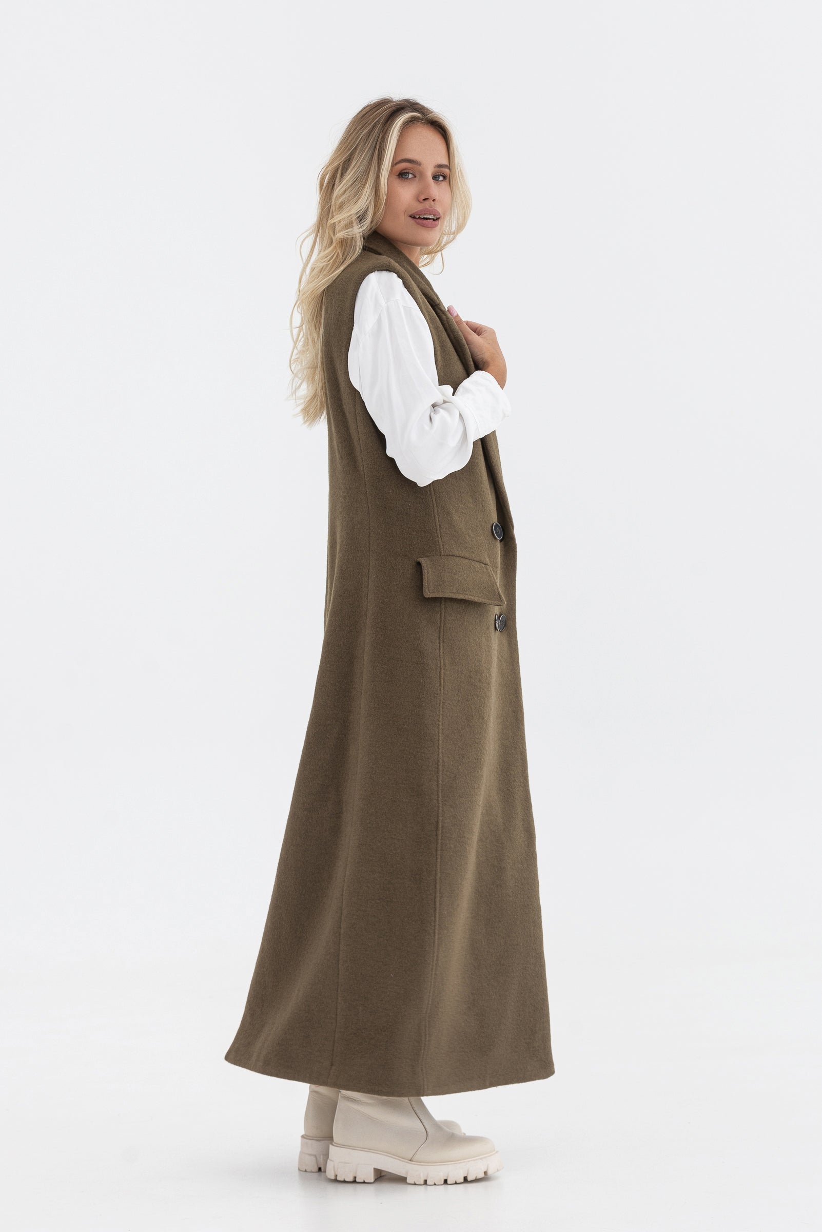 Sleeveless trench coat. Long. Buttoned.