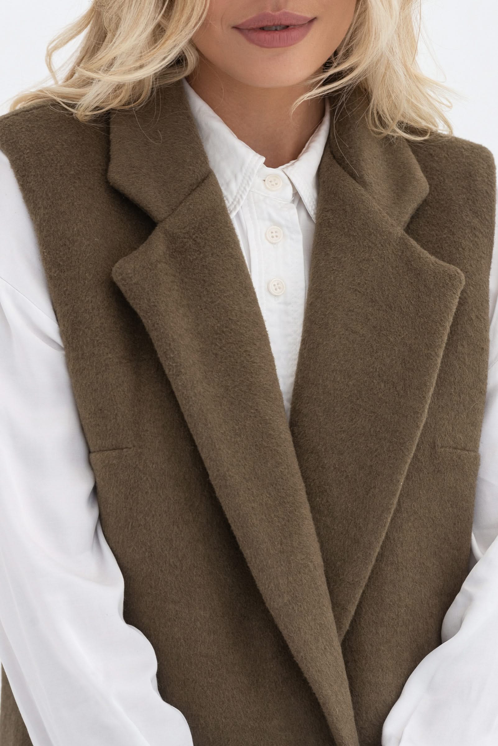Sleeveless trench coat. Long. Buttoned.
